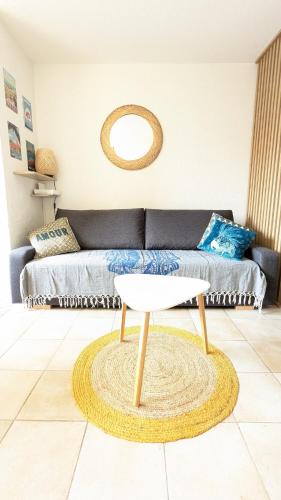 un salon avec un canapé et une table dans l'établissement Appart avec piscine, entre plage, port et falaises, au Cap d'Agde