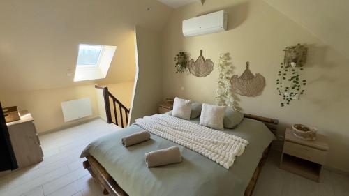 une chambre avec un lit avec deux oreillers dessus dans l'établissement Bulle romantique privé avec Jaccuzi et Sauna, à Fontenoy