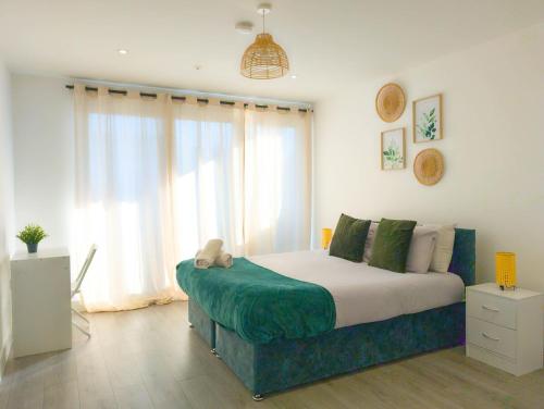 a bedroom with a bed and a large window at Hemel Apartments - The Forest in Hemel Hempstead
