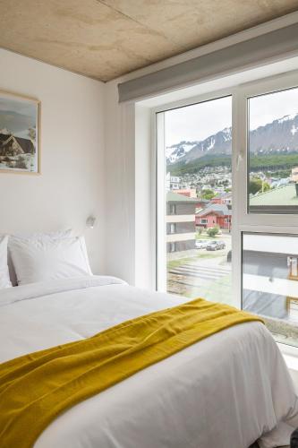 a bedroom with a bed and a large window at Casa Cima in Ushuaia