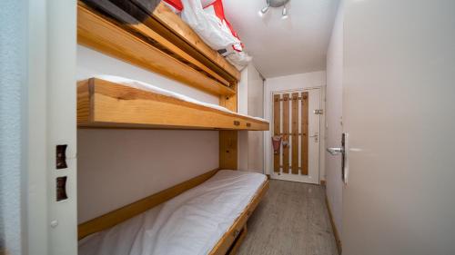 une petite chambre avec un lit et un placard dans l'établissement Les Etoiles D N64 - ST4, à Allos