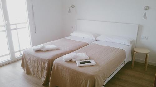 a bedroom with two beds with towels on them at Vila De Premiá in Premiá de Mar