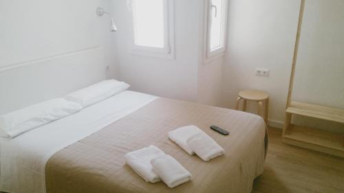 a bedroom with a bed with two towels on it at Vila De Premiá in Premiá de Mar