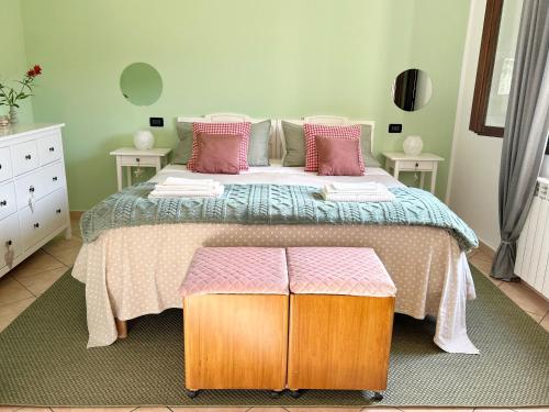 a bedroom with a large bed with pink pillows at ROSMARINO - Comodità e tranquillità con Giardino e Parcheggio in Imperia