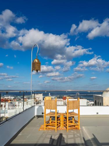 a table and chairs on a balcony with a view of the ocean at RIAD TANJA by chef Moha in Tangier