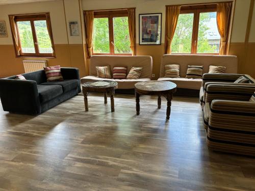 a living room with two couches and two tables at Hotel Taüll in Pla de l'Ermita