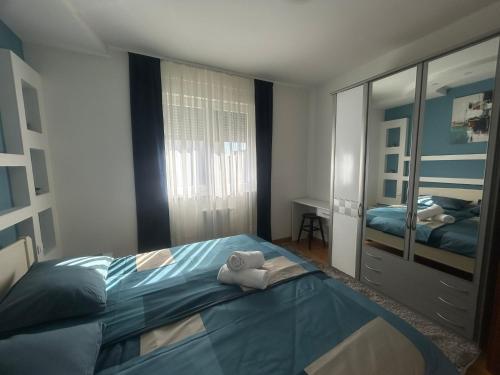 a bedroom with a bed and a mirror at Apartman NOVA in Osijek