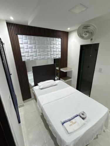a bedroom with a white bed and a mirror at Hotel Rodmary in Saravena