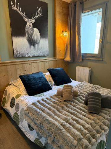 - une chambre avec un grand lit et une photo de cerf sur le mur dans l'établissement Logement cosy à la montagne, à Bourg-Saint-Maurice