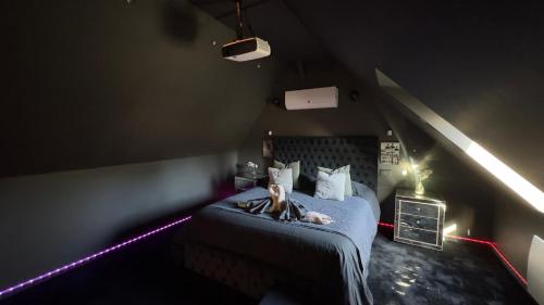 une femme dormant sur un lit dans une pièce éclairée dans l'établissement Magnifique loveroom avec sauna, spa et cinémaroom, à Fontenoy