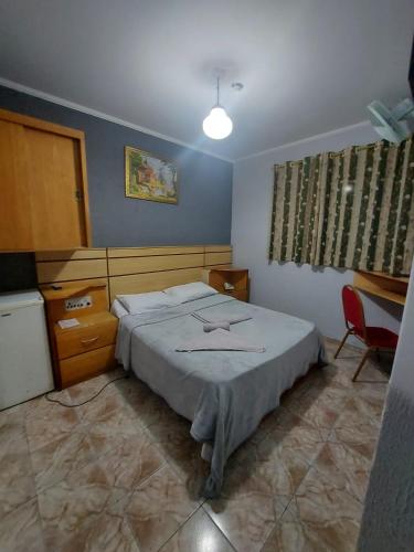 a bedroom with a bed and a table and a chair at Hotel Mooca in Sao Paulo