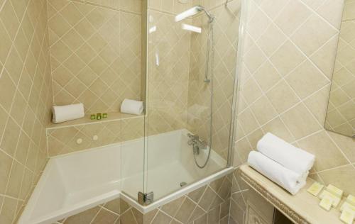 a bathroom with a shower with a tub and a sink at Tulip Inn Beaune in Beaune
