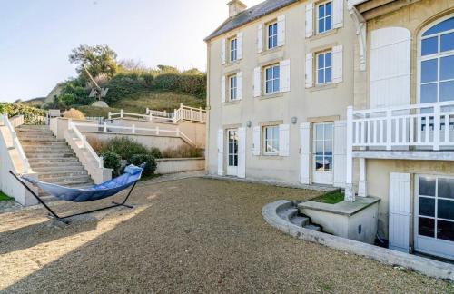 un hamac bleu devant une maison dans l'établissement Maison Historique Vue mer exceptionnelle, à Arromanches-les-Bains