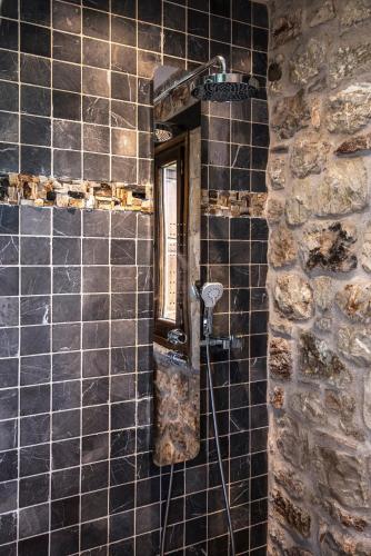 a bathroom with a mirror on a tiled wall at Elafos Spa Hotel in Elliniko