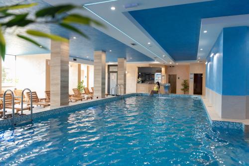 a swimming pool in a hotel with a woman sitting in the middle at Hotel Agape in Zlatibor