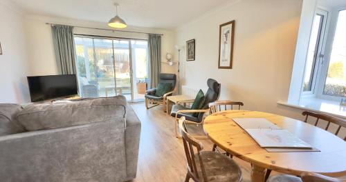 a living room with a couch and a table at Chalkhill View - Idyllic Sea Views Parking in Wyke Regis