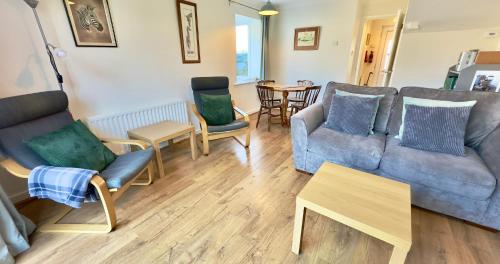 a living room with couches and chairs and a table at Chalkhill View - Idyllic Sea Views Parking in Wyke Regis
