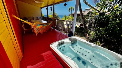 une baignoire jacuzzi sur le côté de la maison dans l'établissement Ti Kaz Coco JUNGLE Jacuzzi & vue mer, à Bouillante