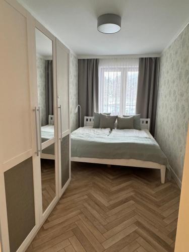 Un dormitorio con una cama y una ventana grande. en Apartament Śnieżny, en Karpacz
