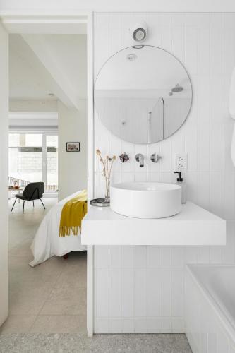 a white bathroom with a sink and a mirror at Casa Cima in Ushuaia