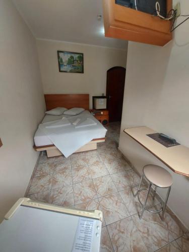 a small bedroom with a bed and a desk at Hotel Mooca in Sao Paulo
