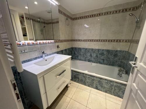 une salle de bain avec un lavabo et une baignoire dans l'établissement Ajaccio appartement vue mer, à Ajaccio
