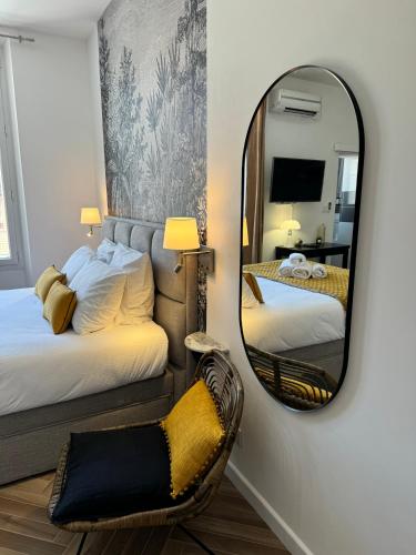 - un miroir dans une chambre avec 2 lits et une chaise dans l'établissement Seaside Cannes Festival Suite, à Cannes