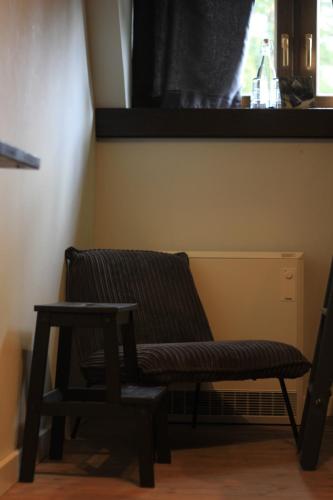 a bench and a stool in a room with a window at EDELFUCHS-LODGE in Bühlertal