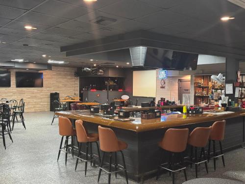a bar in a restaurant with a bunch of stools at Clarion Inn & Suites Dothan South in Dothan