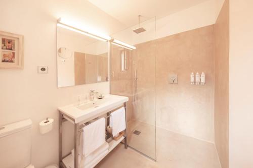 a bathroom with a sink and a shower at Hotel y Apartamentos DES PUIG in Deia