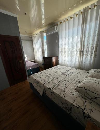 a bedroom with a bed and a window with curtains at Green house in Nukus