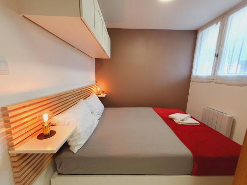 une petite chambre avec un lit et une fenêtre dans l'établissement T2 Magellan Centre-ville - Clim Wifi Terrasse - ROSSIconciergerie - Linge inclus, à La Grande Motte