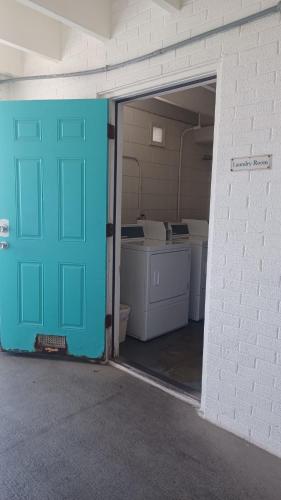 an empty garage with a blue door in a room at COUPLES GETAWAY, HONEYMOON SWEET, Perfectly Cozy Beach Front Condo with kitchen, pool, free parking,CHECK-IN AT DOOR in Panama City Beach
