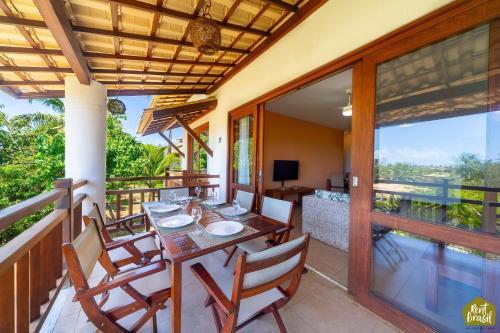 a dining room with a table and chairs on a balcony at Reserva Imbassaí - Apartamento TD 11 02 Superior - Buganvílias in Imbassai