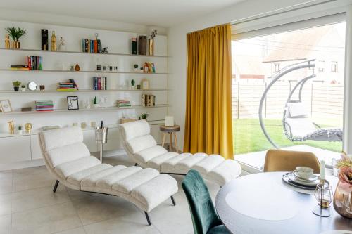 a living room with white chairs and a table at Sauna Moments Villa in Torhout