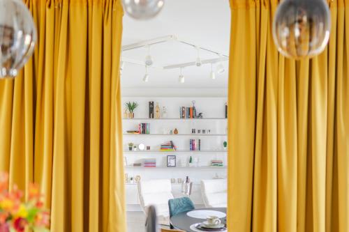 a dining room with yellow curtains and a table at Sauna Moments Villa in Torhout