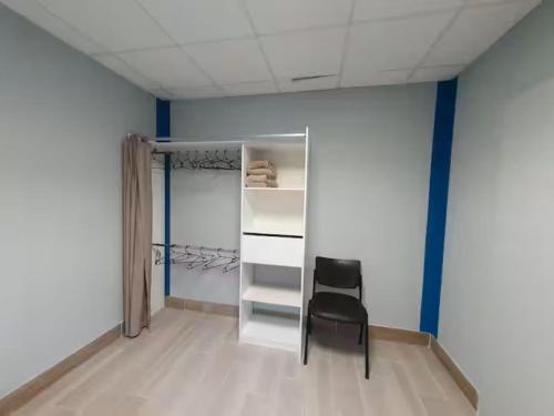 a black chair in a room with a closet at la tanière argentée in Nailloux