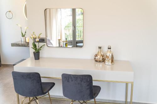 a dining room table with two chairs and a mirror at PERATZADA central suite in Argostoli