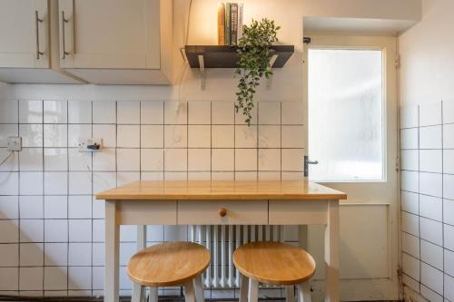 a kitchen with two wooden stools and a counter at Large House, Garden, 3 Bedrooms in Bristol