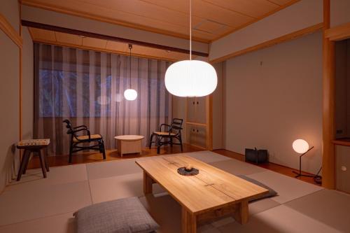 a living room with a wooden table and chairs at くらま温泉 in Kyoto