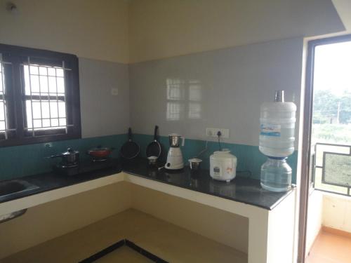 a kitchen with a counter with a water bottle on it at Sanvika Hotels & Service Apartments in Coimbatore