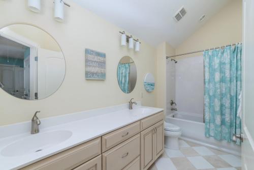 a bathroom with a sink and a toilet and a mirror at Counting Stars! - Retreat on Fripp Island in Fripp Island