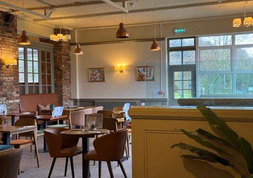 a dining room with tables and chairs and windows at Dragonfly Hotel Bury St Edmunds in Bury Saint Edmunds