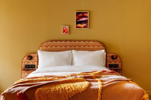a bedroom with a large bed with orange walls at Le Jardin de Verre by Locke in Paris