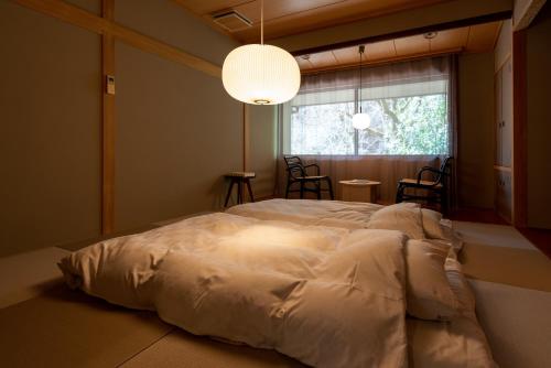 a large bed in a room with a large window at くらま温泉 in Kyoto