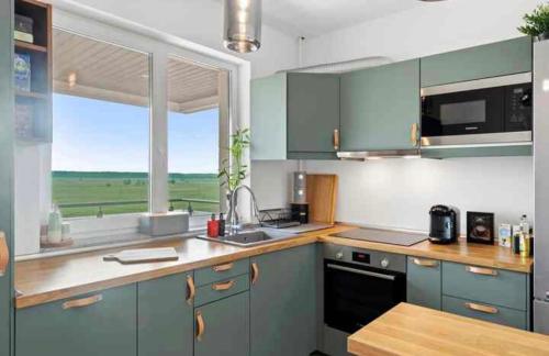 VoluntariにあるCozy Flat North Bucharestのキッチン(青いキャビネット付)、大きな窓