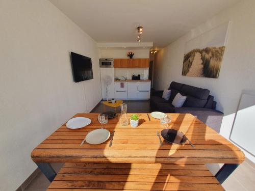 - une grande table en bois dans le salon dans l'établissement T2 Magellan Parking privé WIFI - Centre-ville - ROSSIconciergerie - Linge en option, à La Grande Motte