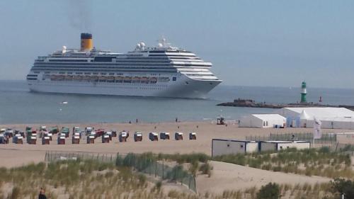 a cruise ship is docked at a beach at Suite Sand-Düne in Warnemünde