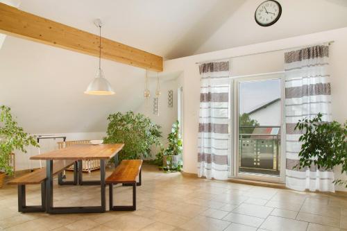 a dining room with a table and a clock on the wall at Christines Ferienwohnung in Eitting