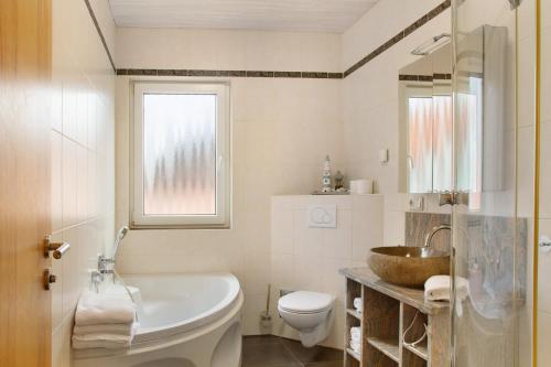 a bathroom with a tub and a sink and a toilet at Christines Ferienwohnung in Eitting